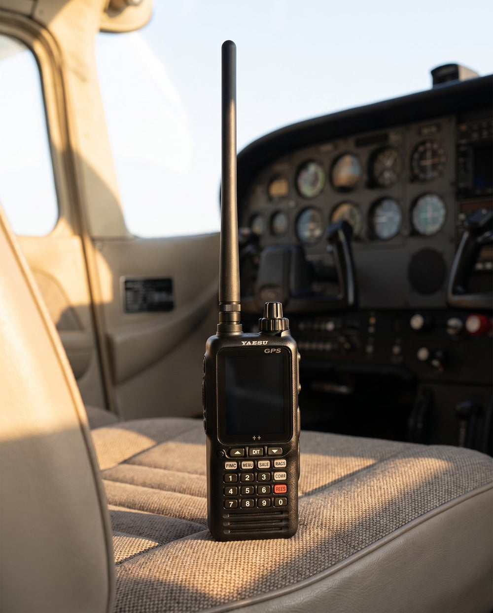 Radio Yaesu FTA-850L apagado sobre el asiento del copiloto de una avioneta
